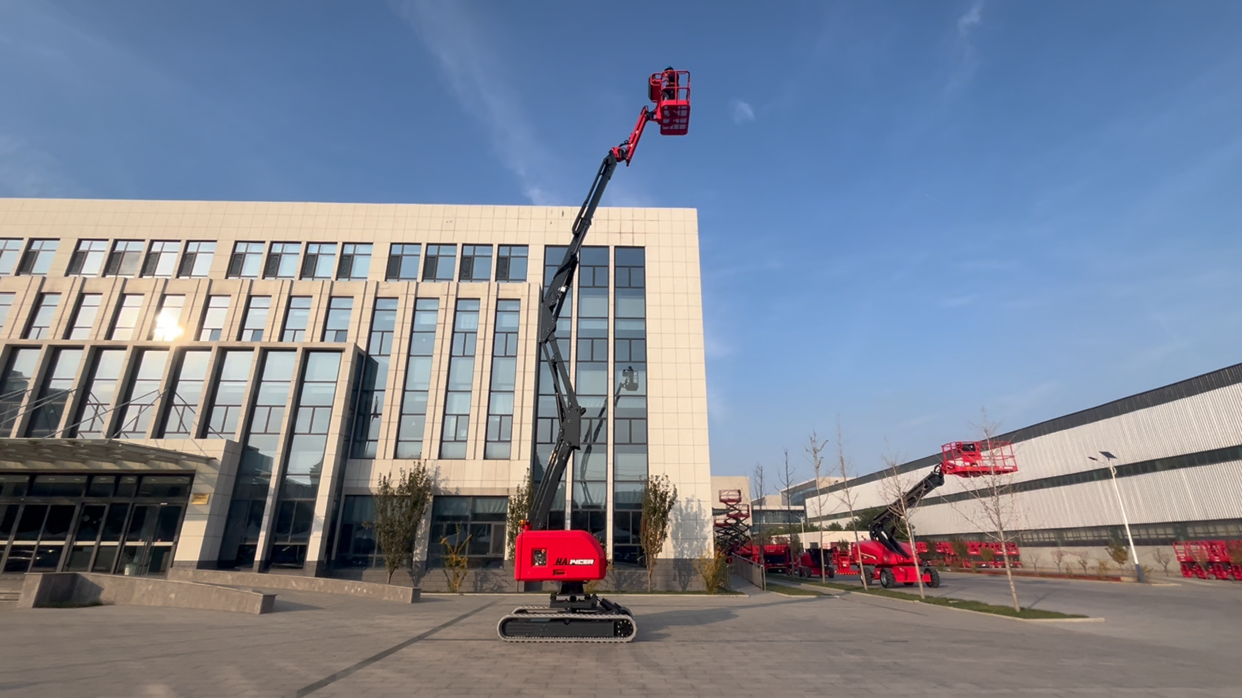 Red HERED HA12CEA crawler articulating boom lift in stowed position