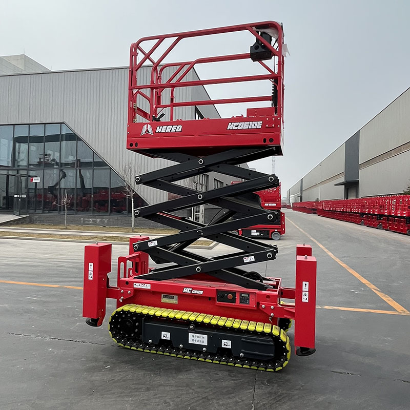 Red HERED HC0610E crawler scissor lift in stowed position with outriggers