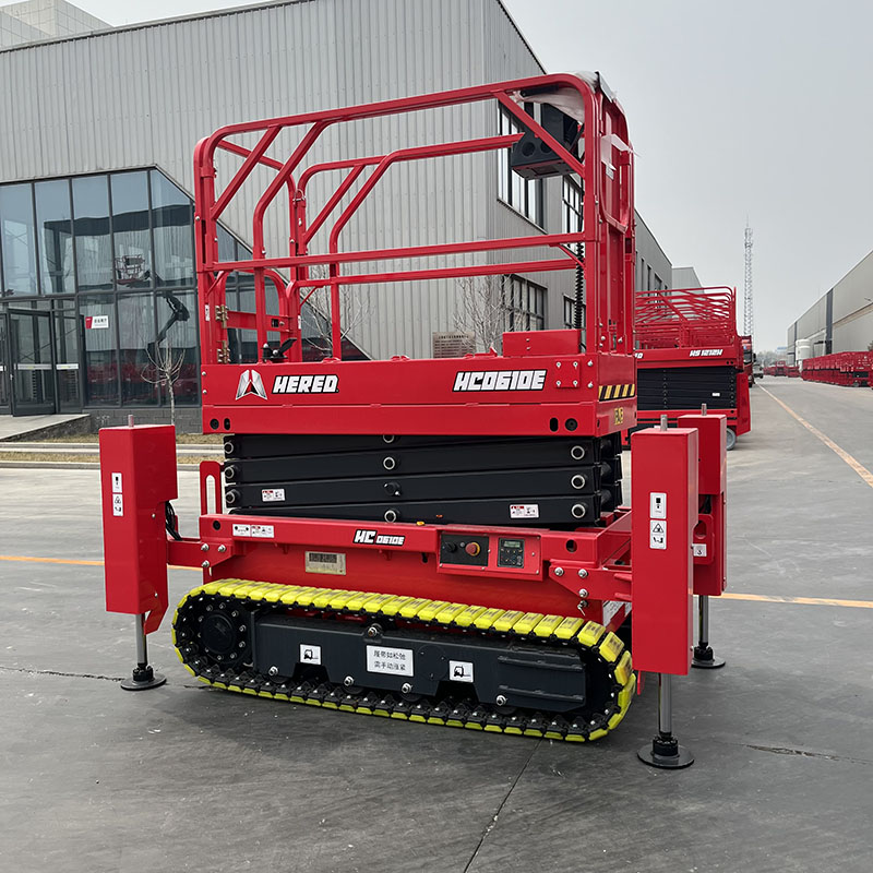 Red HERED HC0610E crawler scissor lift in stowed position with outriggers