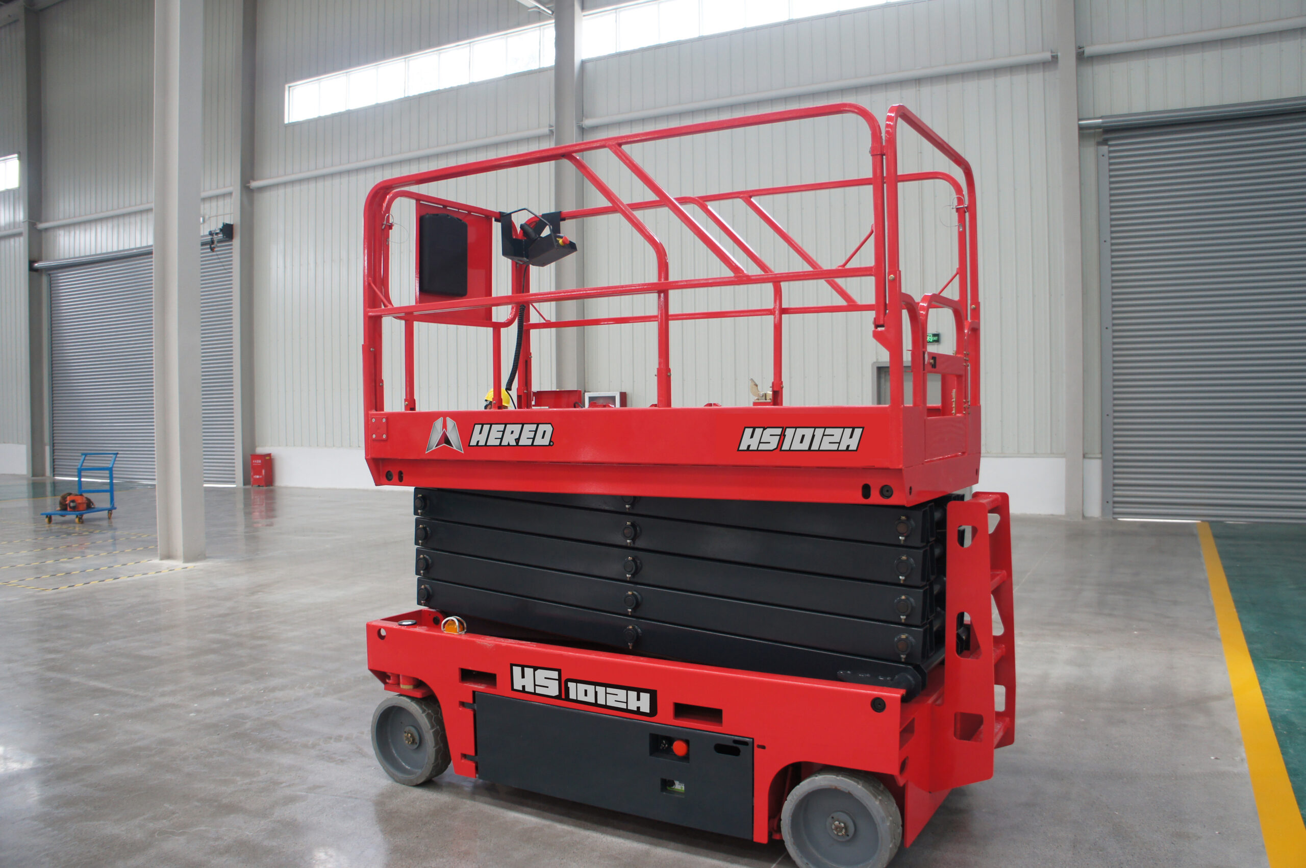Red HERED HS1012E electric slab scissor lift in stowed position indoors