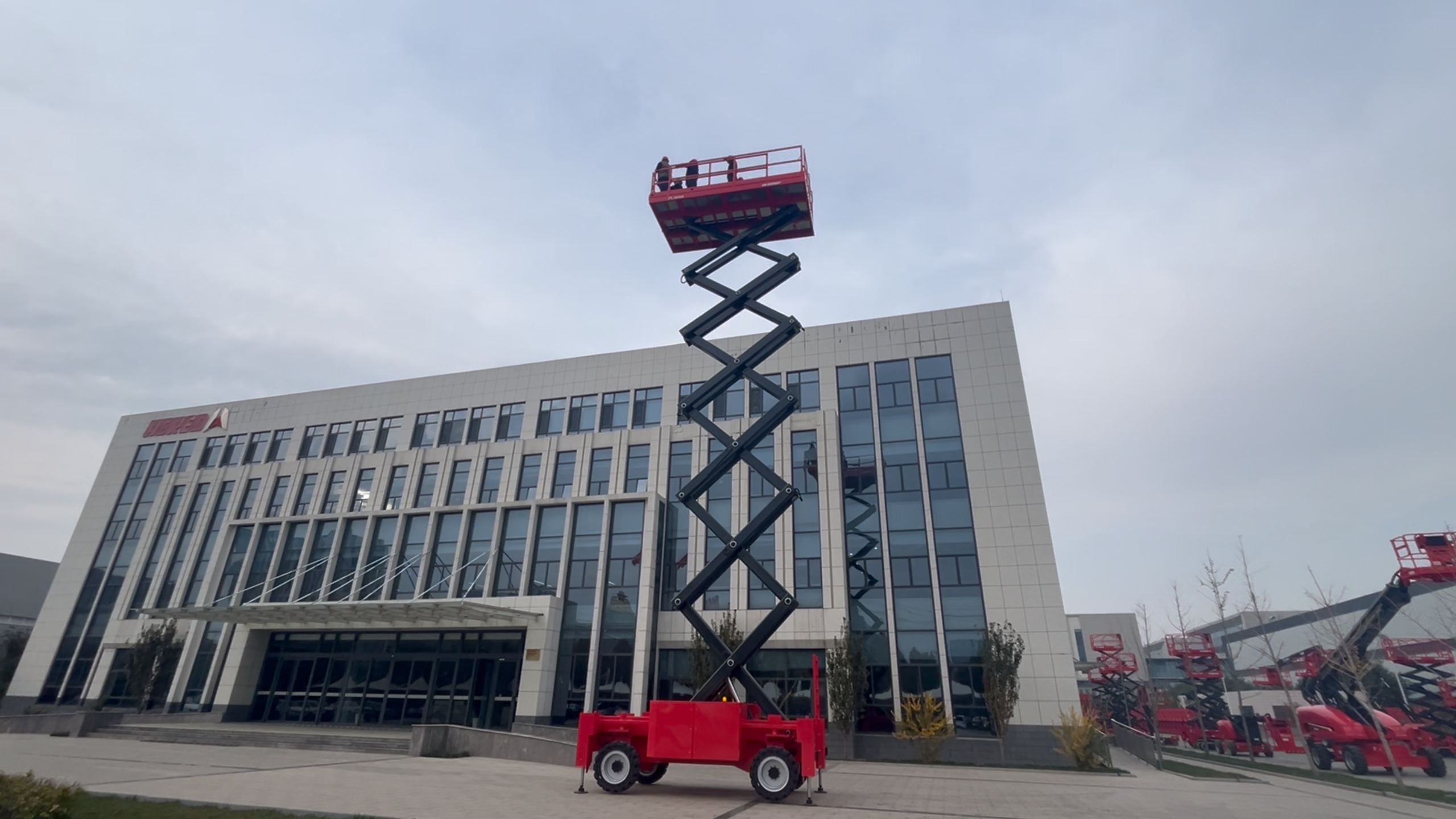 Red HERED HS2025ERT rough-terrain scissor lift with the deck slightly raised