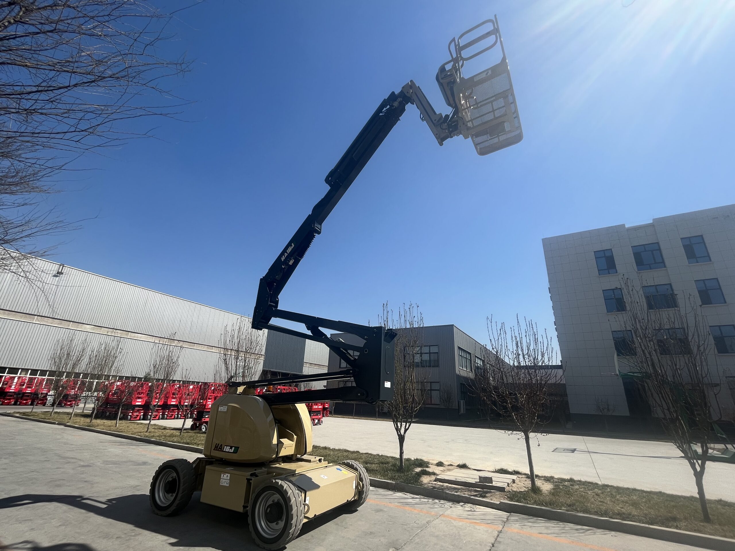 Beige HERED HA16RJE articulating boom lift in stowed position