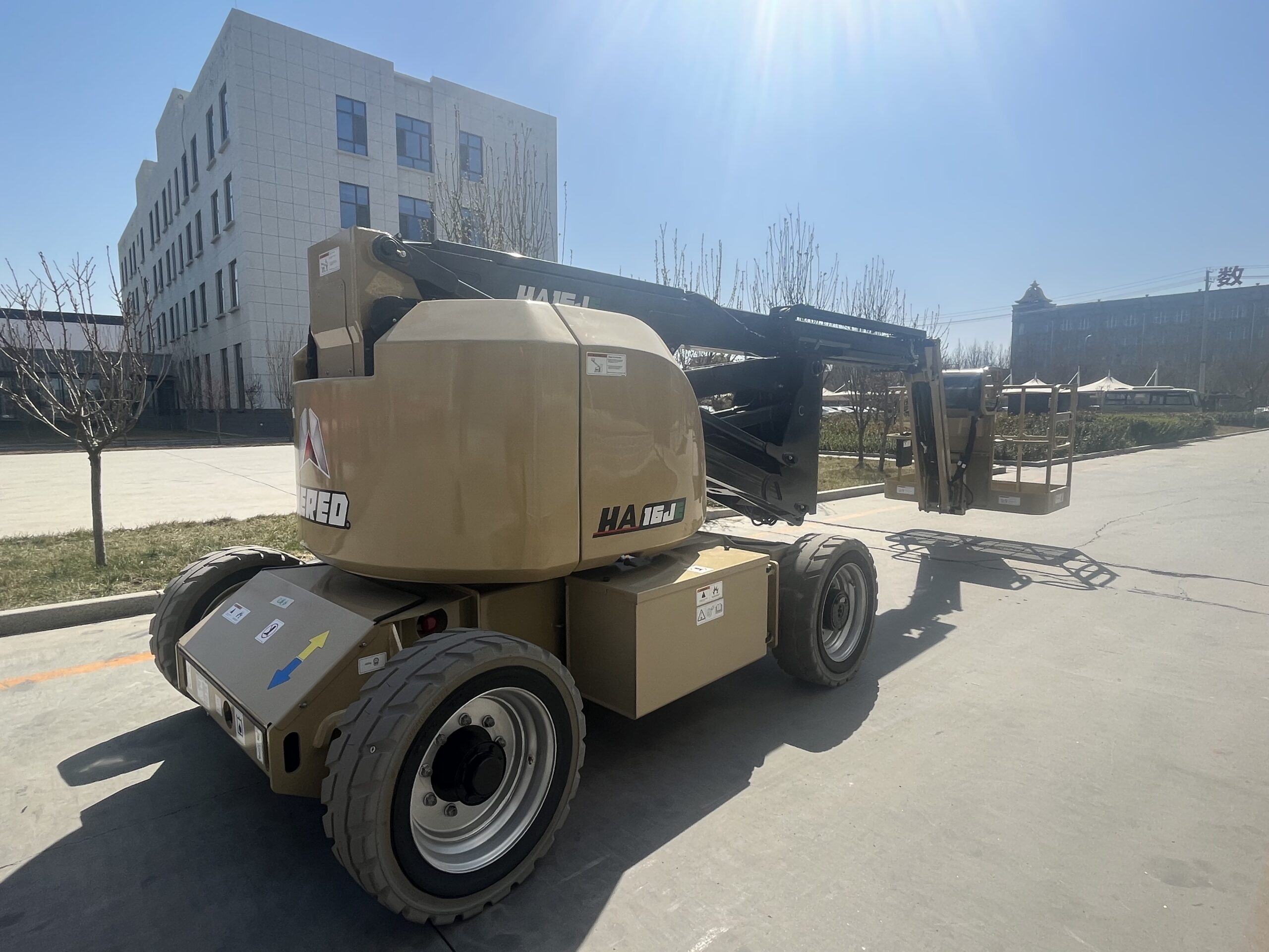 Beige HERED HA16RJE articulating boom lift in stowed position