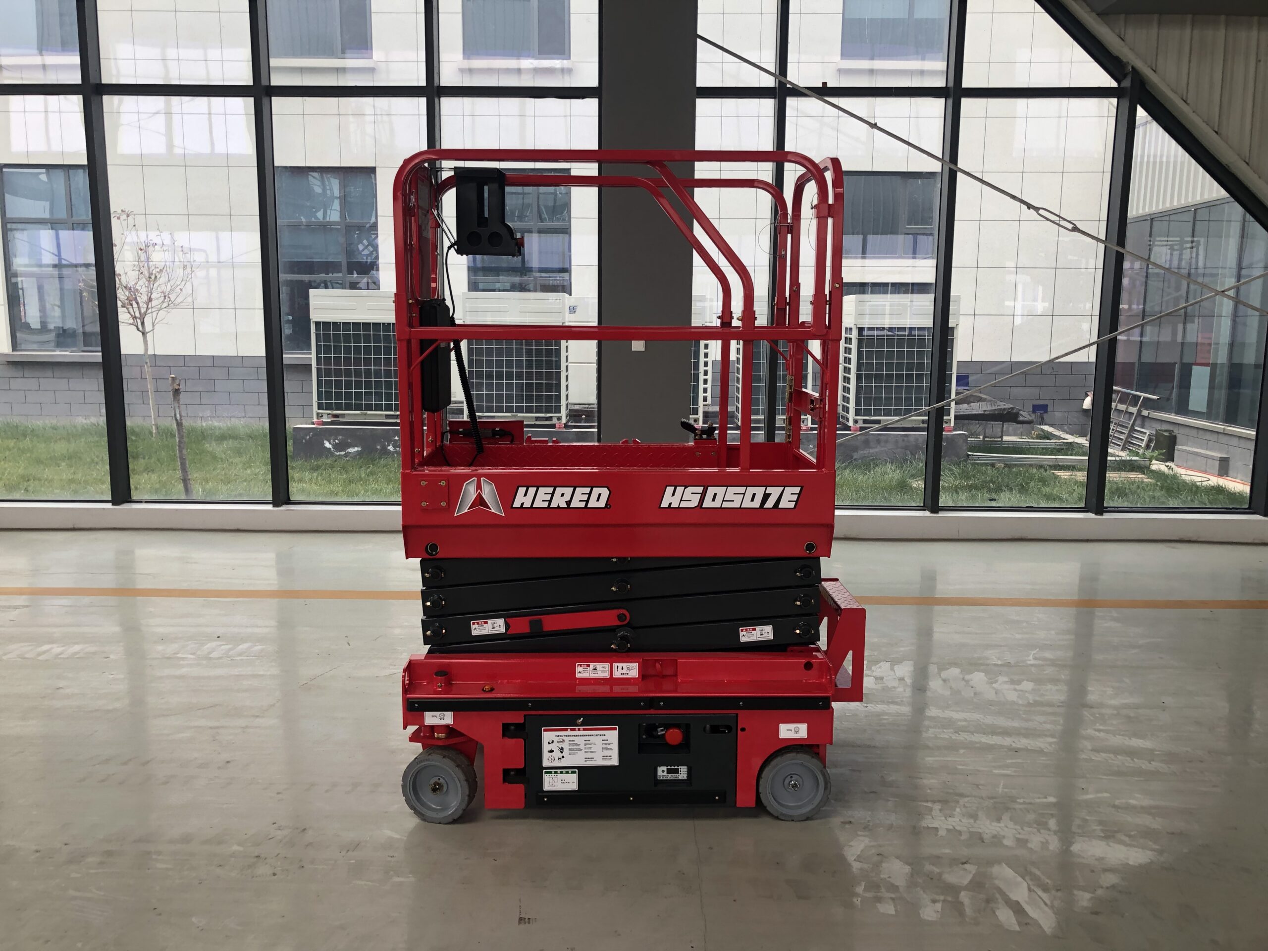 Red HERED HS0507E electric slab scissor lift in stowed position indoors