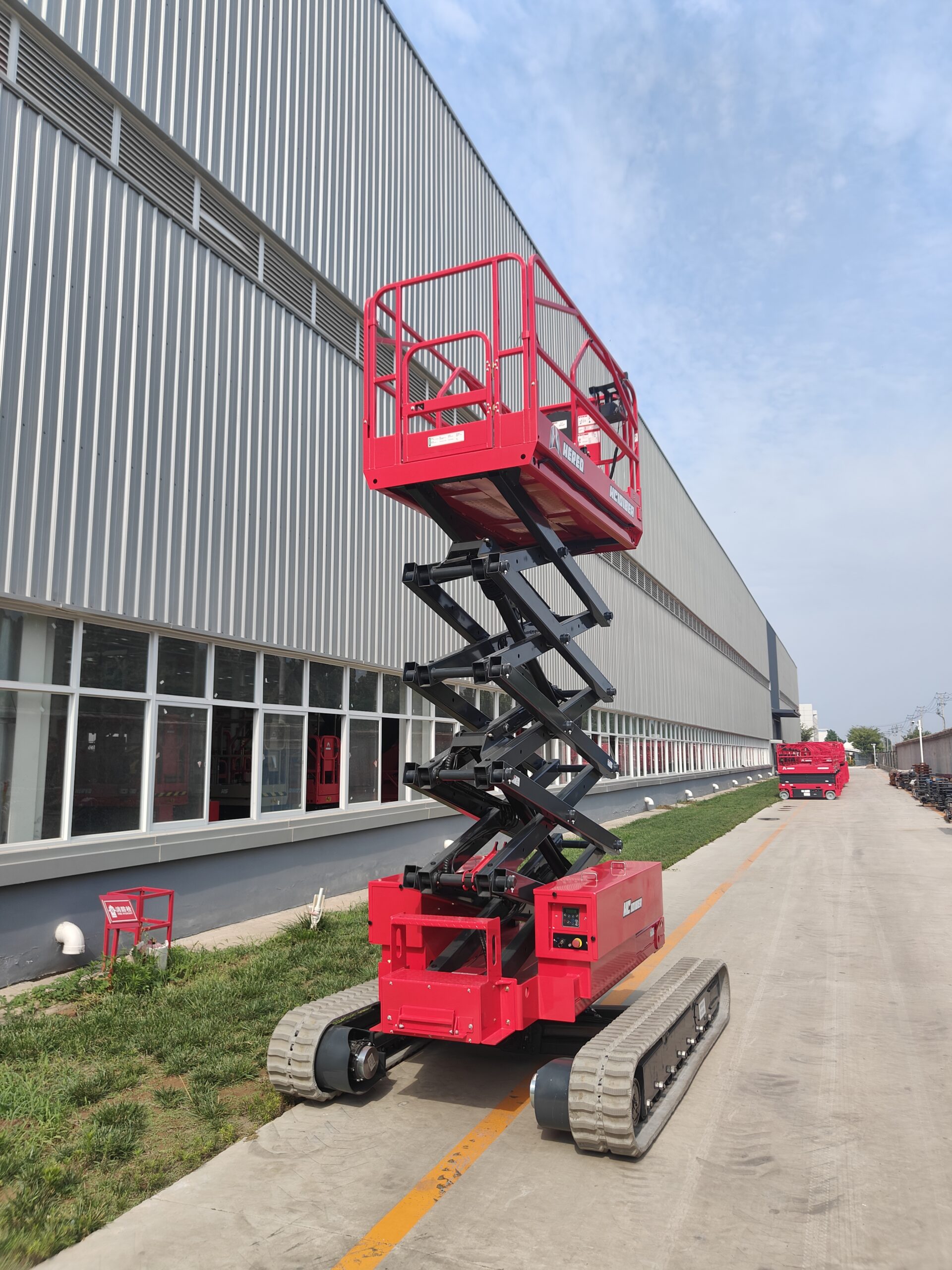 Red HERED HC1018EA auto-levelling crawler scissor lift in stowed position